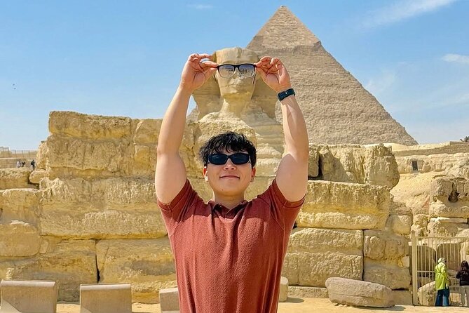 Visitor posing with the Great Sphinx and a Giza pyramid