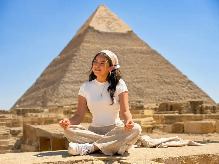 Visitor sitting in front of a Giza pyramid