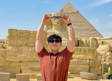 Visitor posing with the Great Sphinx and a Giza pyramid